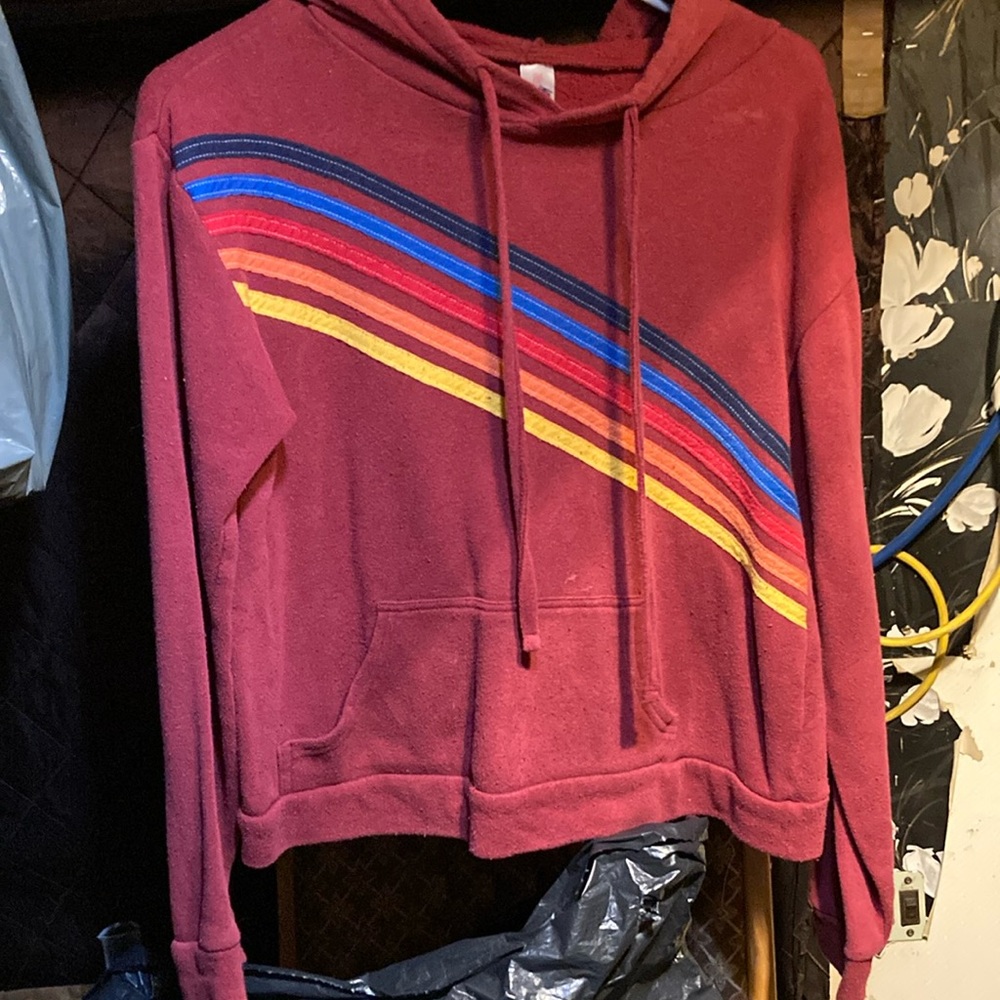 A maroon,with yellow,orange,red, blue,dark blue stripes on the front,hoodie